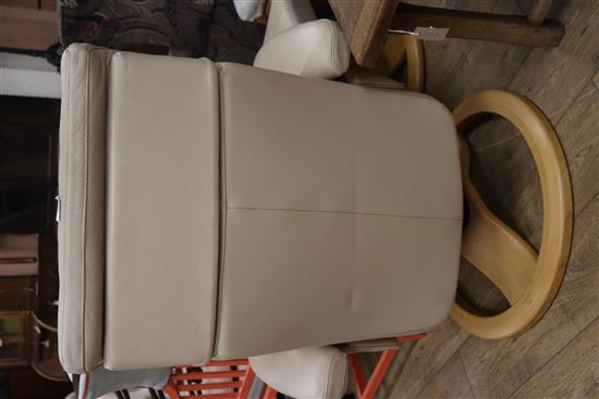 A cream leather reclining armchair and footstool